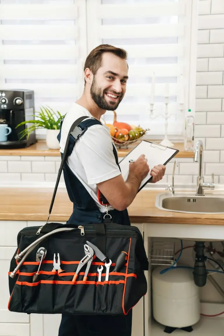 Image of plumber man with equipment and clipboard working in apartment